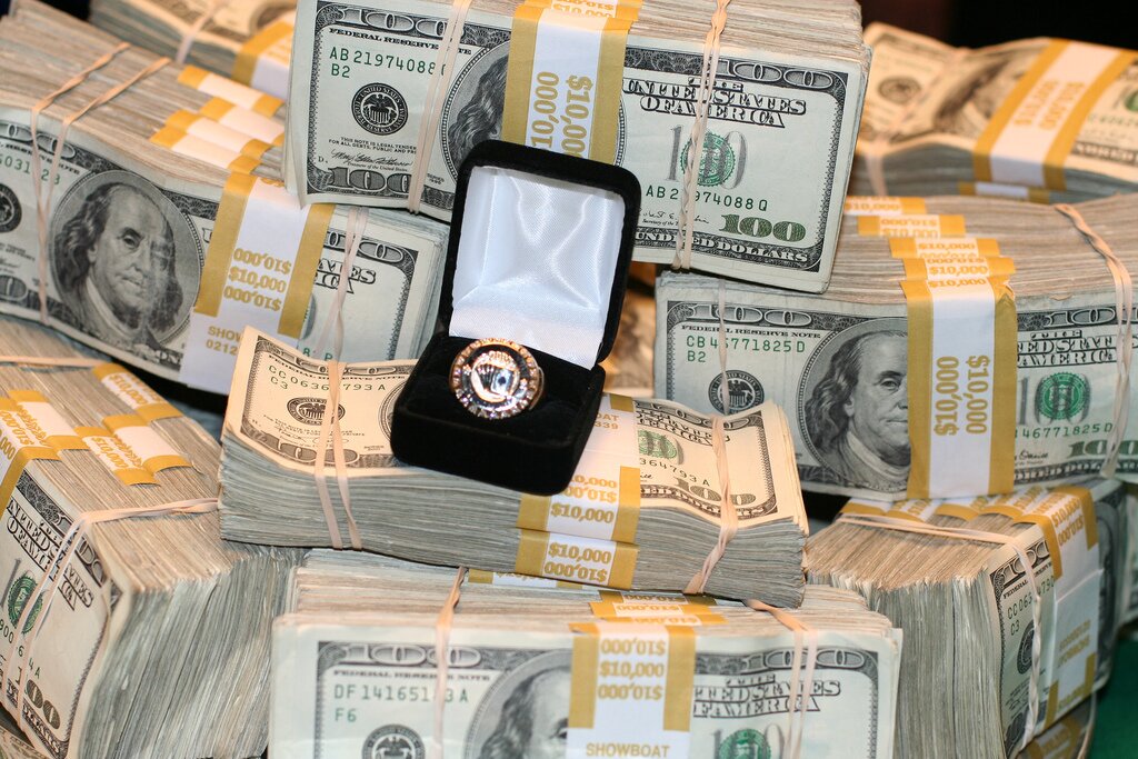 Poker Millionaires - piles of dollars with WSOP ring